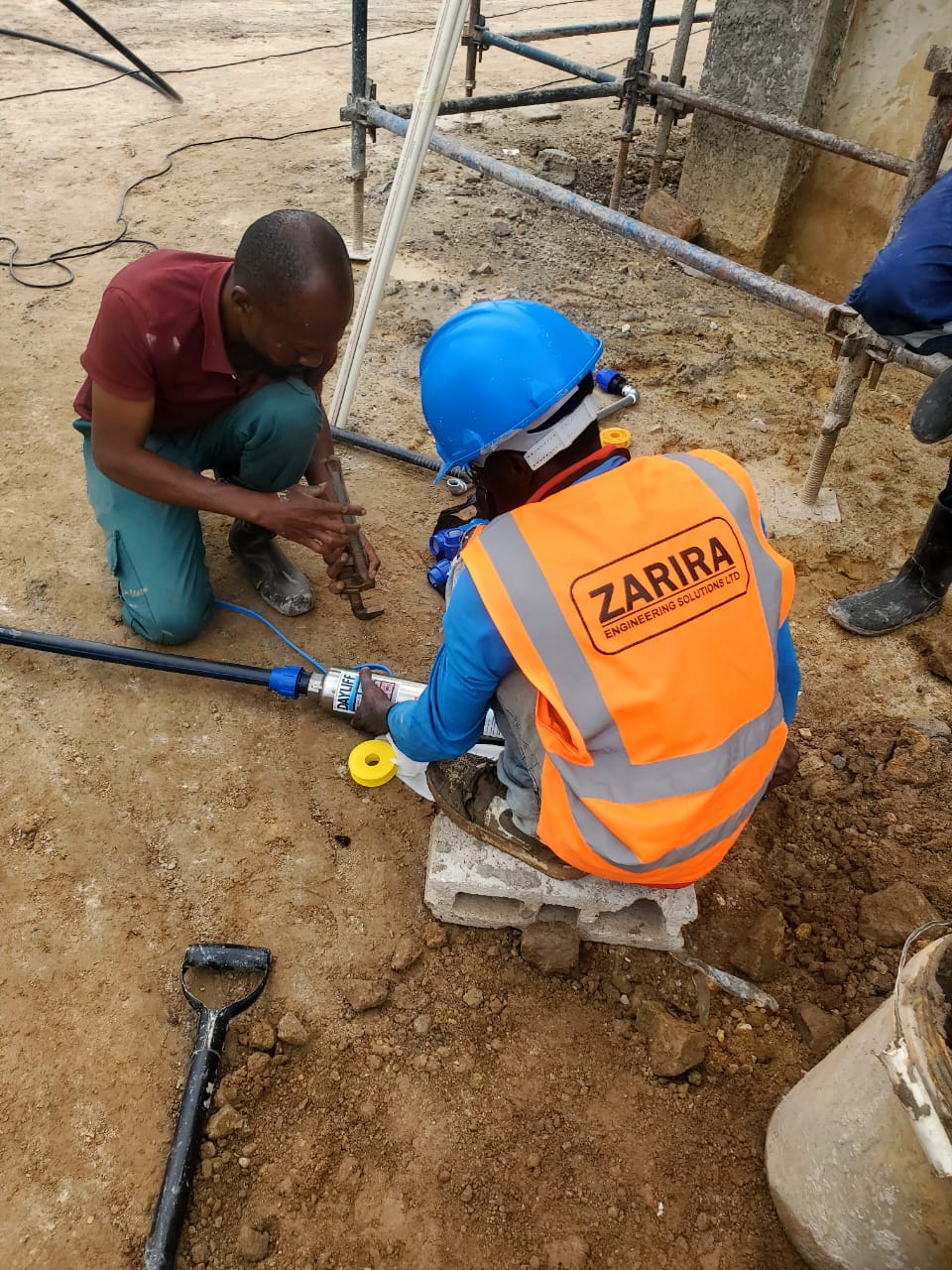 Technicians installing pipework connections for borehole water supply system